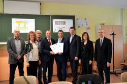 Oberbürgermeister Sven Wagner (4.v.l.) erhält den Fördermittelbescheid von Finanzminister André Schröder (5.v.l.). Über die bevorstehende Sanierung des Schulzentrums Nord freuen sich insbesondere die Leiterin der Gemeinschaftsschule 'Hermann Kasten', Verena Frank (2.v.l.) und der Leiter der Grundschule Nord, Ingo Kurze (l.). [(c): Stadt Staßfurt/Julia Föckler]