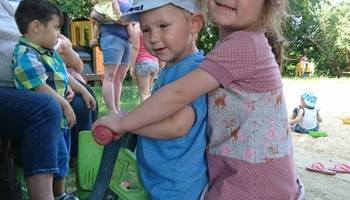 Zwei Kinder (Mädchen und Junge) auf einem Laufrad