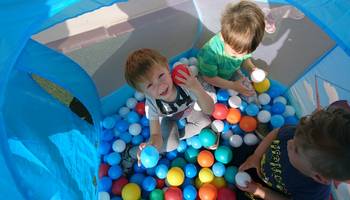 Drei kleine Jungs spielen in einem Bällebad